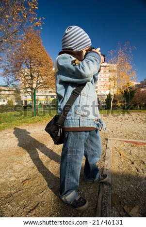 Image of a boy taking pictures outside