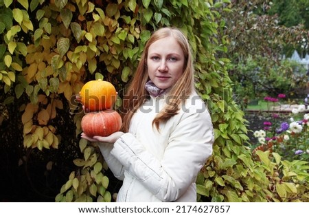 young girl with a harvest of pumpkins in the garden