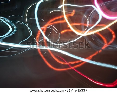 Abstract night light painting of passing by vehicles background. Blurred photography