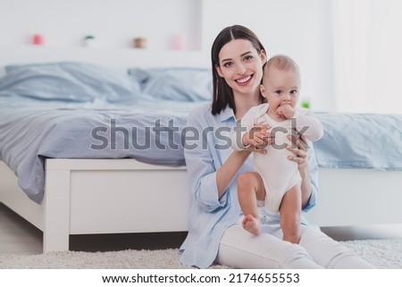 Photo of sweet charming small baby mom wear blue shirt teaching walking smiling indoors home room Royalty-Free Stock Photo #2174655553