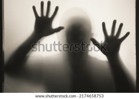 Horror, halloween background - Shadowy figure behind glass of a man Royalty-Free Stock Photo #2174658753