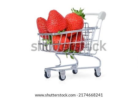 Large strawberries lie in a metal shopping trolley with a gray handle, isolate, white background, shadow