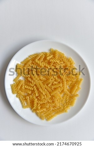 Yellow twisted raw pasta in realistic style on white background.