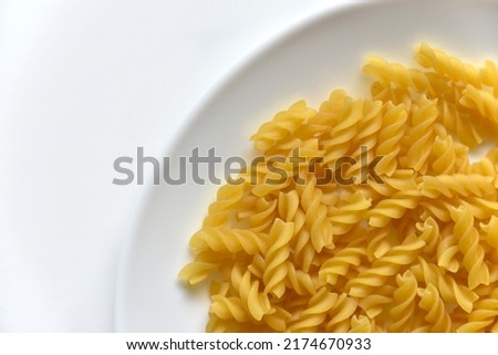 Yellow twisted raw pasta in realistic style on white background.
