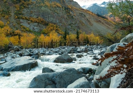 Beautiful atmospheric mountain landscape stormy river, autumn trees, mountains on a sunny day. Beautiful autumn mountain landscape