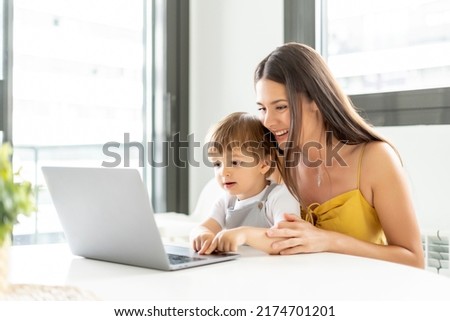 Woman with her little son using laptop