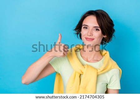 Photo of charming sweet woman wear green t-shirt showing thumb up isolated blue color background