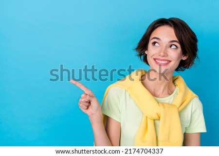 Photo of dreamy sweet lady dressed yellow pullover pointing finger looking empty space isolated blue color background