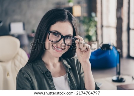 Photo of young cheerful lovely woman hand touch eyeglasses support website testing designer leader indoors
