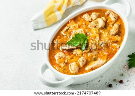 Chicken spicy goulash in pot. Top view, copy space. Royalty-Free Stock Photo #2174707489