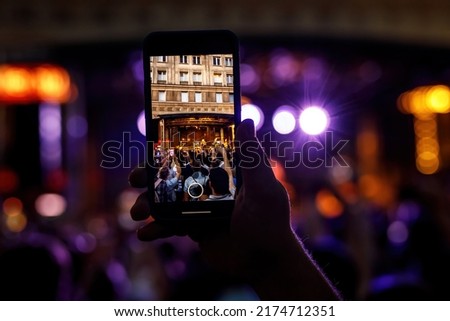 People holding their smartphones at concert and taking pictures