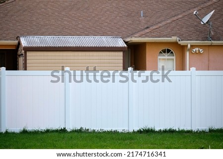 White plastic fence for back yard protection and privacy Royalty-Free Stock Photo #2174716341