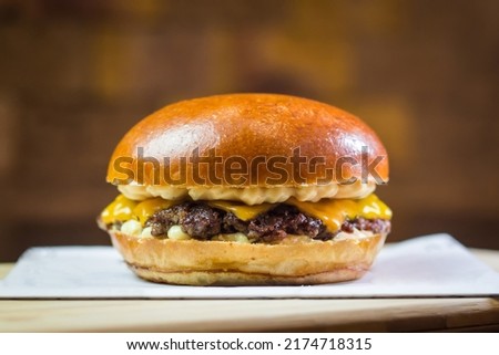Smash Burger in a wood table and a brick background Royalty-Free Stock Photo #2174718315