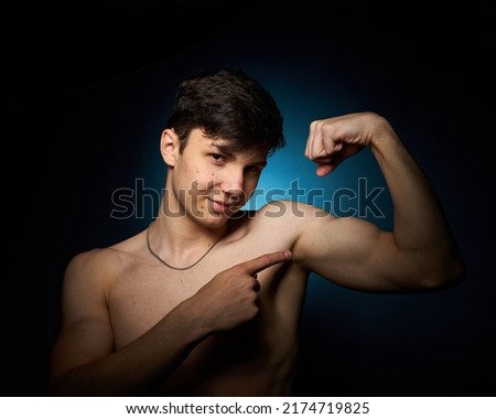 Healthy athletic teenager shows off his body against a dark background, the concept of proper nutrition