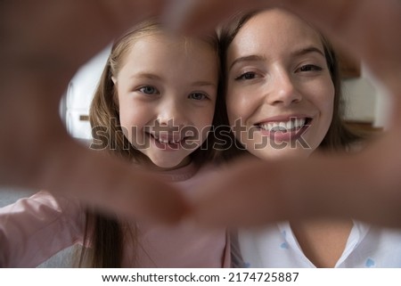 Cute faces of mom and daughter join fingers showing heart symbol, close up cropped shot. Happy Mothers Day, unconditional love, bloggers record video, family share sincere feelings, videocall concept Royalty-Free Stock Photo #2174725887