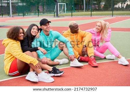 Multi-ethnic group teenage friends. African-american asian caucasian student spending time together Multiracial friendship Happy smiling People dressed colorful sportswear meeting outdoor sportground Royalty-Free Stock Photo #2174732907