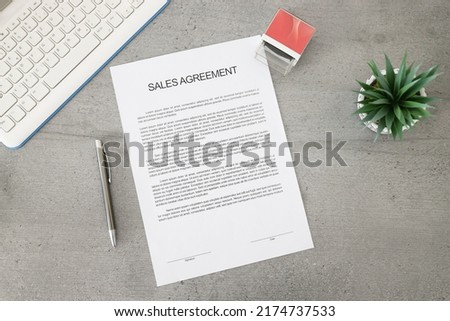 Business document paper of sale agreement. Waiting to sign sales agreements on a desk with a pen, stamp, and plant. Business contract. Royalty-Free Stock Photo #2174737533