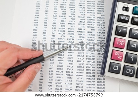 The concept of statistics, financial analysis, business, economics. Business woman's hand points to the numbers.