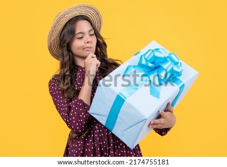 pondering teen girl with present box on yellow background