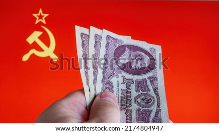 Old Soviet 25 Ruble bills in front of USSR flag