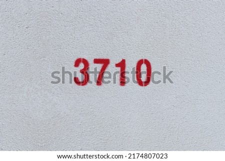 Red Number 3710 on the white wall. Spray paint.
