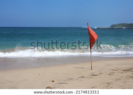 Red flag in the beach. It is a symbol of dangerous beach because of high waves.