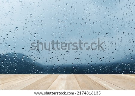 Wooden floor on raindrops on the window glass on blurred  nature