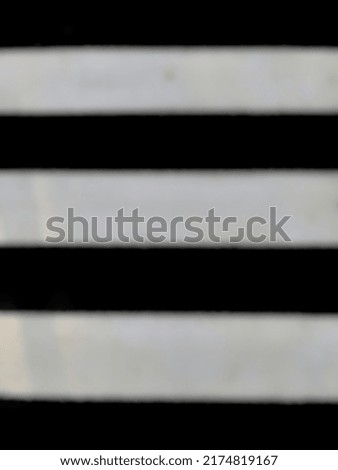 defocused abstract background of zebra cross with white color starting to fade at the highway intersection.