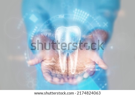 Medical concept, doctor's hands in a blue coat close-up and tooth hologram. X-ray of the jaw, ultrasound. Medical care, anatomy, dentist appointment. mixed media. Royalty-Free Stock Photo #2174824063