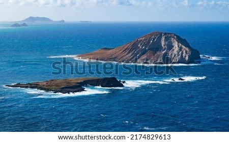 Mānana Island also known as rabbit island and Kāohikaipu Island also known as black rock in the foreground of the picture. In the background of the picture are the Mokulua Islands, the Mokumanu island