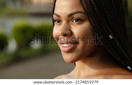 Portrait of a young smiling African woman with dreadlocked pigtails on her head.
