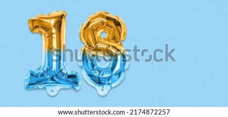 Rainbow foil balloon number, digit eighteen on a blue background. Birthday greeting card with inscription 18. Top view. Numerical digit. Celebration event, template. Banner.