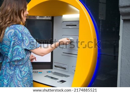 Cropped photo of a caucasian woman withdrawing money from the ATM