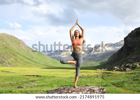 Front view portrait of a yogi in a high mountain field doing yoga exercise Royalty-Free Stock Photo #2174891975
