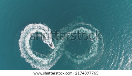 Aerial top view of a white pleasure boat on a summer day. Powerboat turn loop eight on the sea making metaverse infinity future concept.  Royalty-Free Stock Photo #2174897765