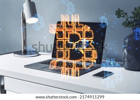 Cryptocurrency concept with orange glowing digital bitcoin sign on modern laptop on white office table background, double exposure