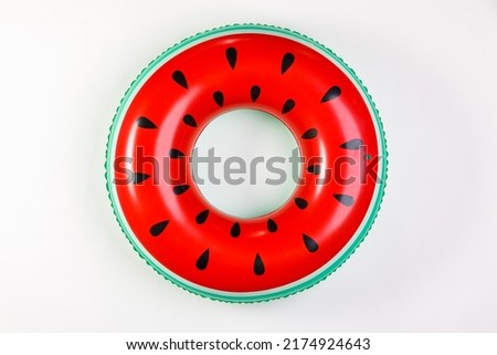 Top view closeup isolated studio shot of colorful red and green watermelon with black seeds round shape swimming pool lifesaver kid rubber ring using on sea beach vacation placed on white background. Royalty-Free Stock Photo #2174924643