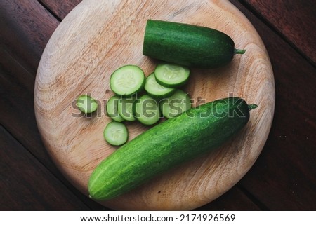 green cucumbers on the wood table