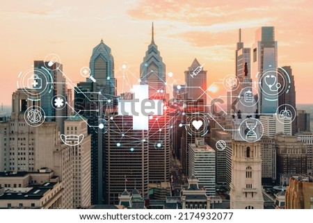 Aerial panoramic cityscape of Philadelphia financial downtown, Pennsylvania, USA. City Hall Clock Tower, sunset. Hologram healthcare digital medicine icons. The concept of treatment from disease