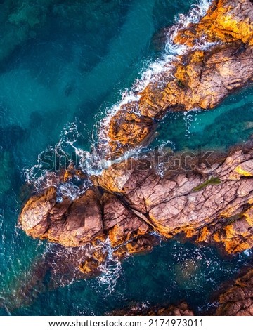 Aerial view of the seascape of the rocks and the turquoise blue sea. Conceptual background of summer beach vacations.