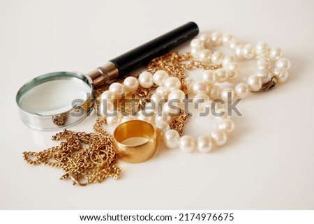 many golden and silver jewerly and magnifying glass, pawnshop concept, jewerly shop concept, closeup Royalty-Free Stock Photo #2174976675