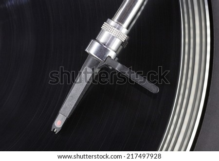Dj needle stylus on spinning record, closeup