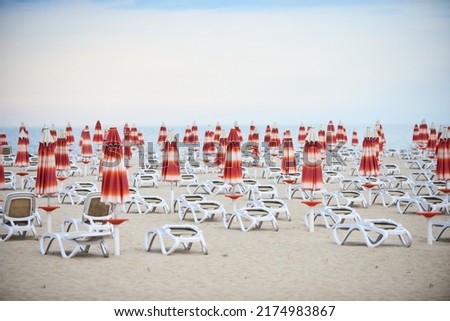 View of umbrellas and chairs on sandy beach and sea. Empty beach waiting for tourists. nobody