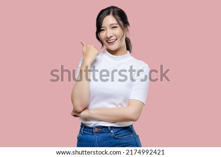 Happy young Asian woman feeling happiness and gesture thumb up on isolated pink background with copy space. Royalty-Free Stock Photo #2174992421