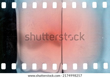 Dusty and grungy 35mm film texture or surface. Perforated scratched camera film isolated on white background. Royalty-Free Stock Photo #2174998257