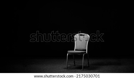 A chair in a black room. Chair on the stage for recording an interview or blog. Place for an interview Royalty-Free Stock Photo #2175030701
