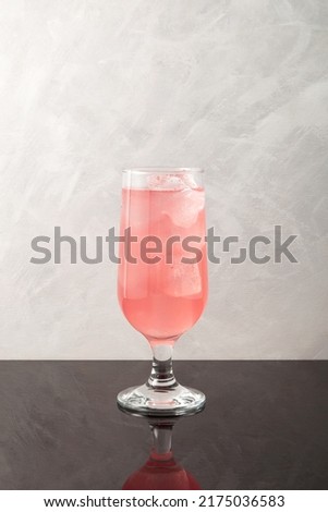 Grapefruit cocktail with ice cubes in tall drinking glass. Pink refreshing summer drink. Royalty-Free Stock Photo #2175036583