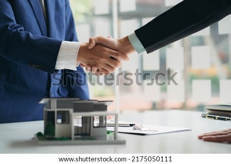 Real estate professionals and clients discussing home purchases, insurance or real estate loans. Home sales agents sit at the office with new homebuyers in the office Royalty-Free Stock Photo #2175050111