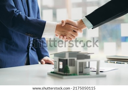 Real estate professionals and clients discussing home purchases, insurance or real estate loans. Home sales agents sit at the office with new homebuyers in the office Royalty-Free Stock Photo #2175050115