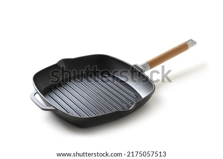 Cast iron grill pan with wooden handle isolated on white background. Royalty-Free Stock Photo #2175057513